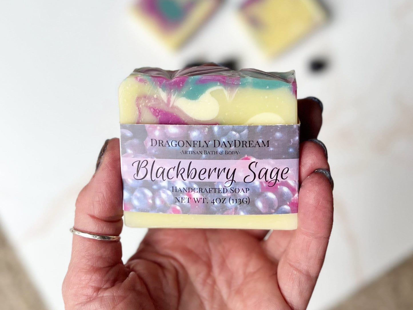 One bar of blackberry sage soap held in hand to show size. 4oz