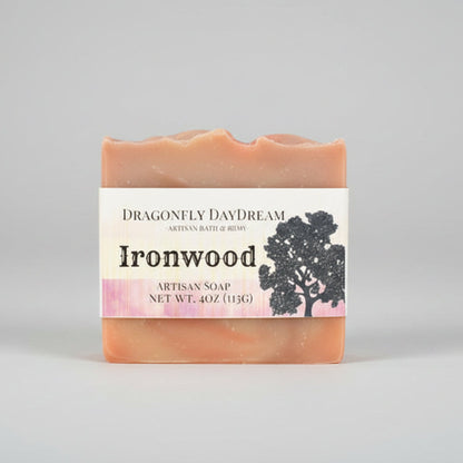 Artisan soap bar with soft brown swirls sitting on a wooden table.  