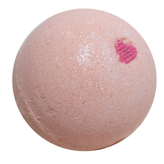 Round pink/peach colored bath bomb with candy heart and white glitter on white background