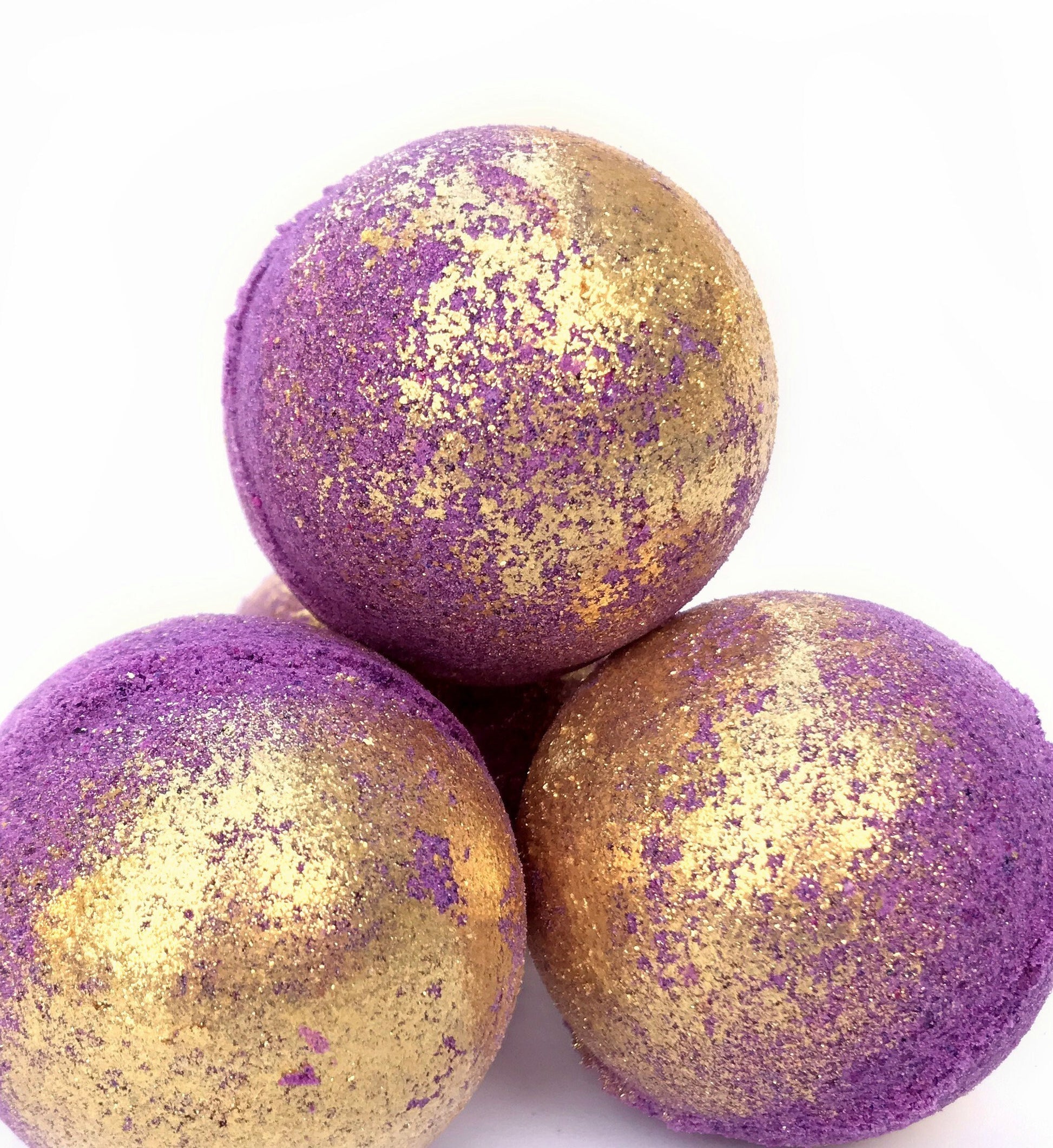 Three eclipse (purple bath bomb with gold eco-glitter) bath bombs stacked